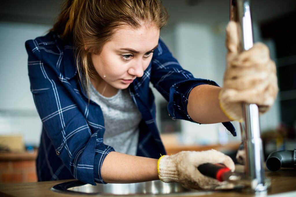 woman fixing kitchen sink